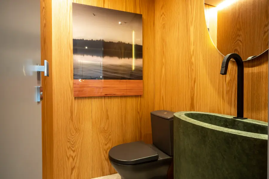 Lavabo do decorado de 90 m² com revestimento em madeira e cuba verde